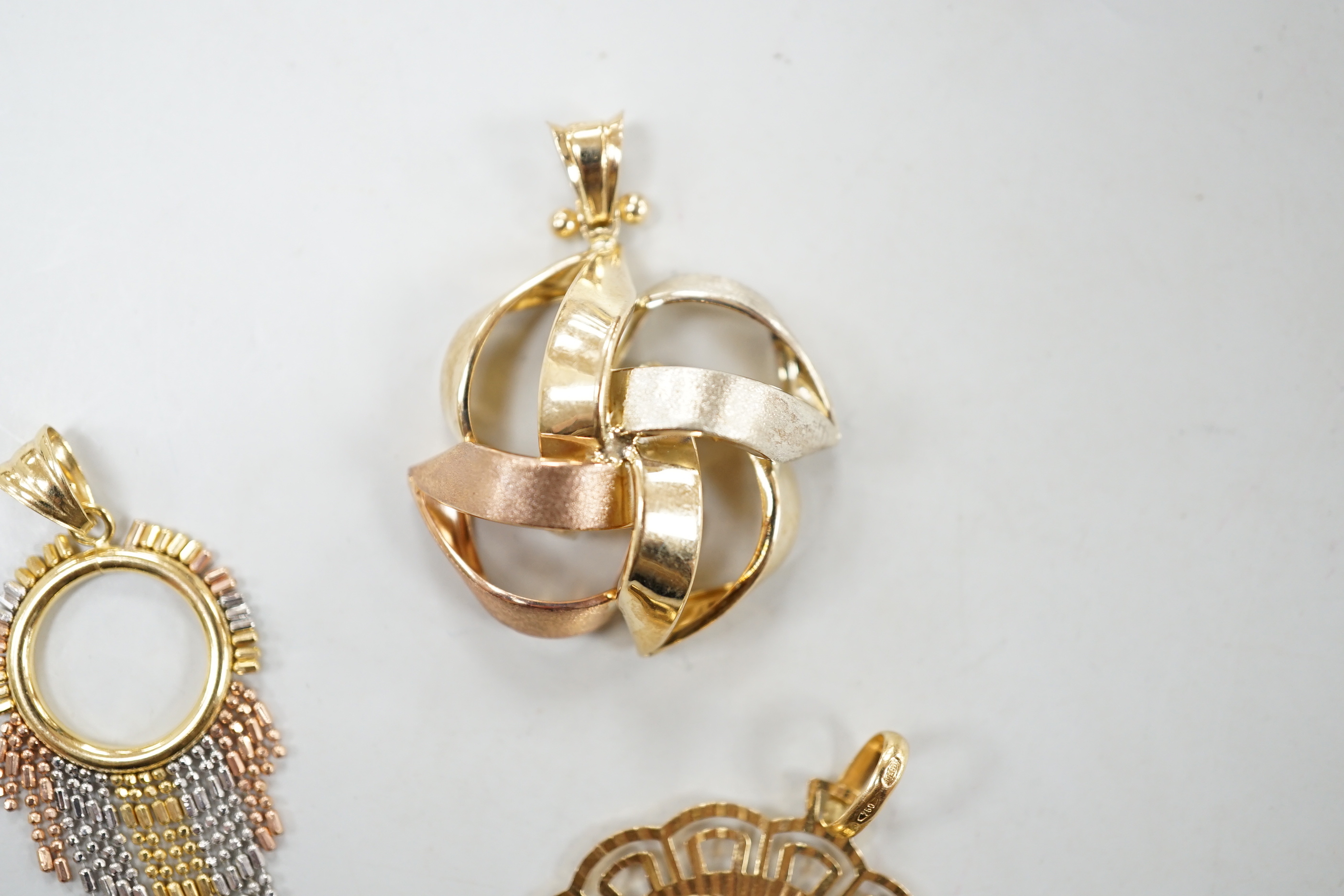 A modern Italian Uno-A-Erre 750 yellow metal Nefertiti pendant, diameter 32mm, 6.6 grams and two three colour 9ct gold pendants, 6.1 grams.